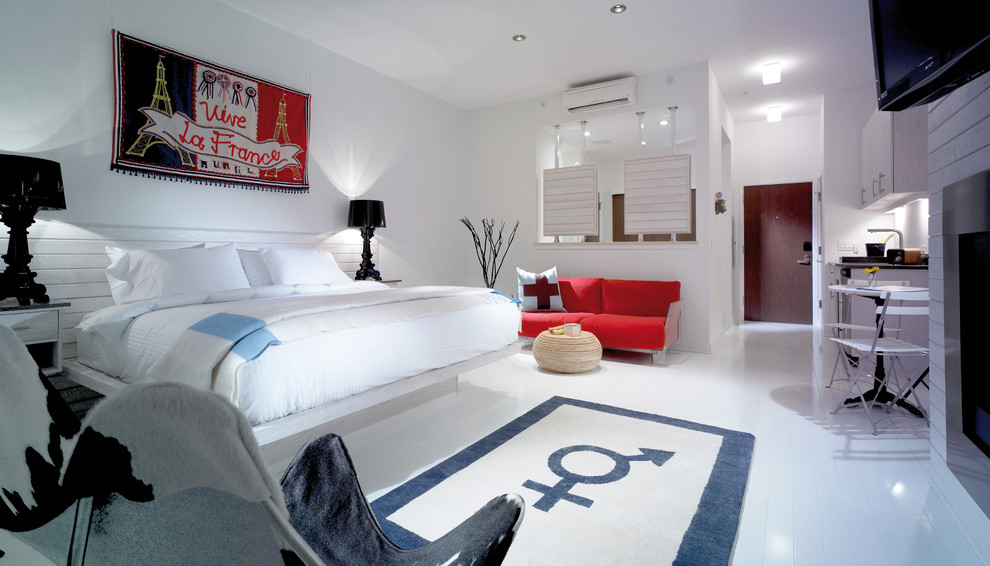 Immagine di una grande camera da letto stile loft contemporanea con pareti bianche, pavimento in legno verniciato e cornice del camino in metallo