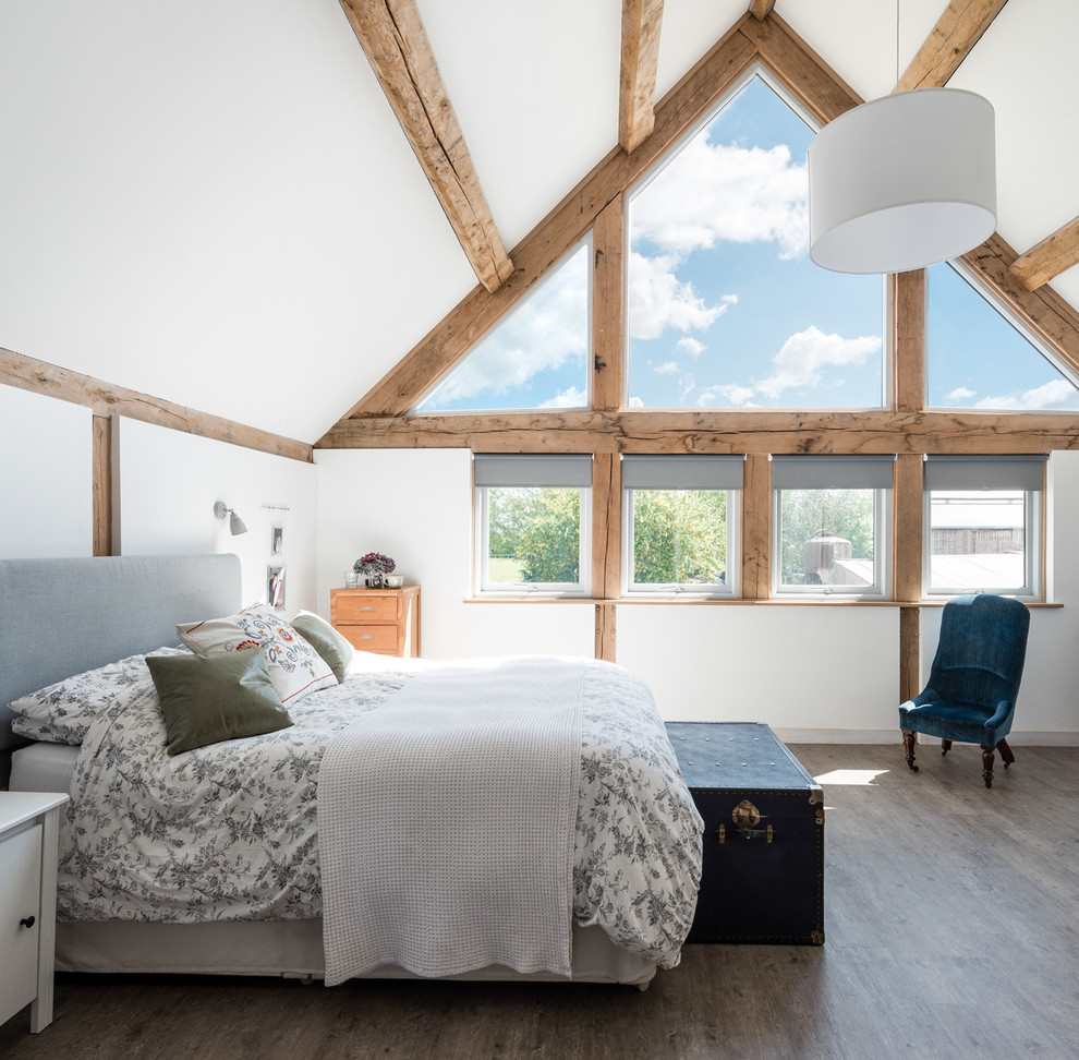 Foto di una camera da letto country con pareti bianche, pavimento in legno massello medio e pavimento grigio