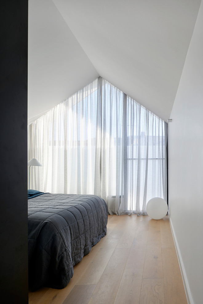 Esempio di una camera matrimoniale design di medie dimensioni con pareti bianche, parquet chiaro e pavimento marrone