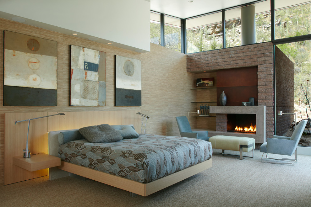 Cette photo montre une très grande chambre tendance avec un mur beige, une cheminée standard, un manteau de cheminée en béton et un sol gris.