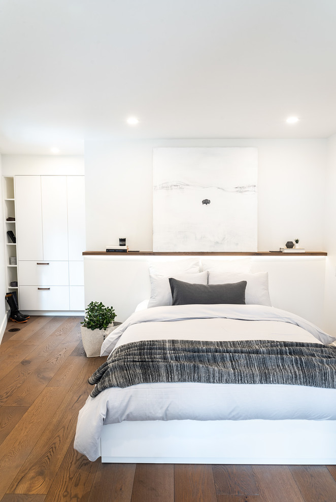 Стильный дизайн: хозяйская спальня в стиле модернизм с белыми стенами и коричневым полом - последний тренд