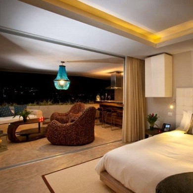 Imagen de dormitorio tipo loft moderno grande sin chimenea con paredes beige, suelo de baldosas de cerámica y suelo beige
