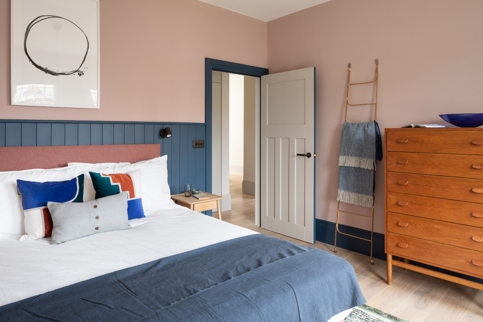 ロンドンにある北欧スタイルのおしゃれな寝室 (ピンクの壁、淡色無垢フローリング、暖炉なし)