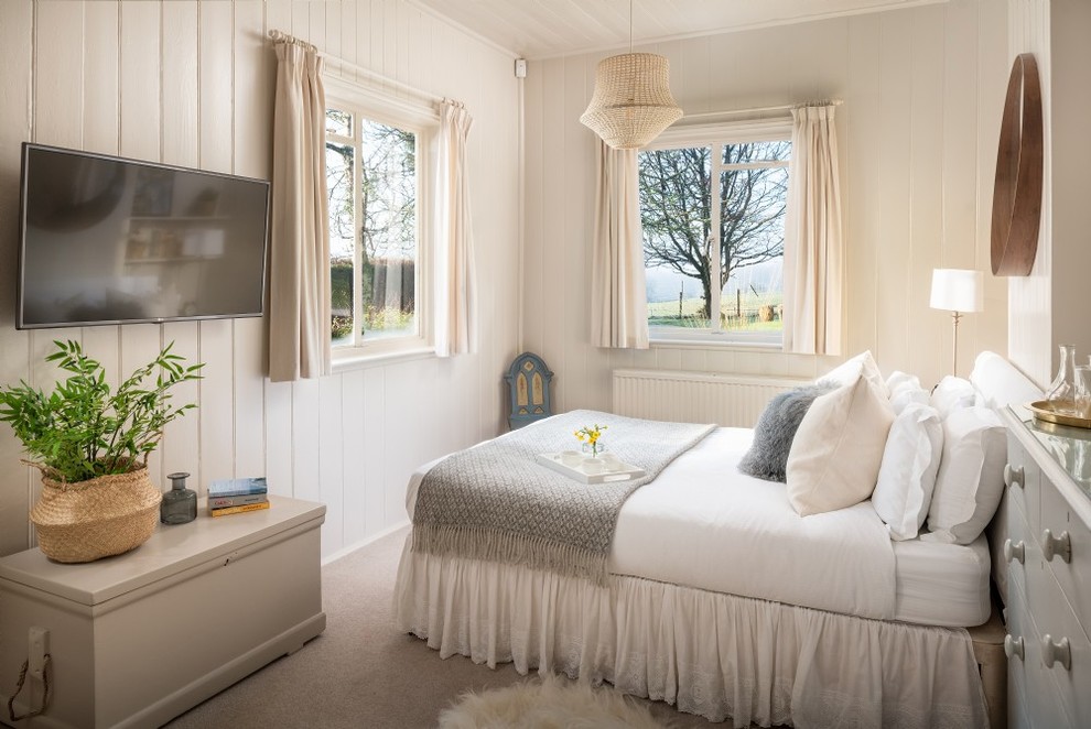 Country bedroom in Hampshire with beige walls, carpet and grey floors.