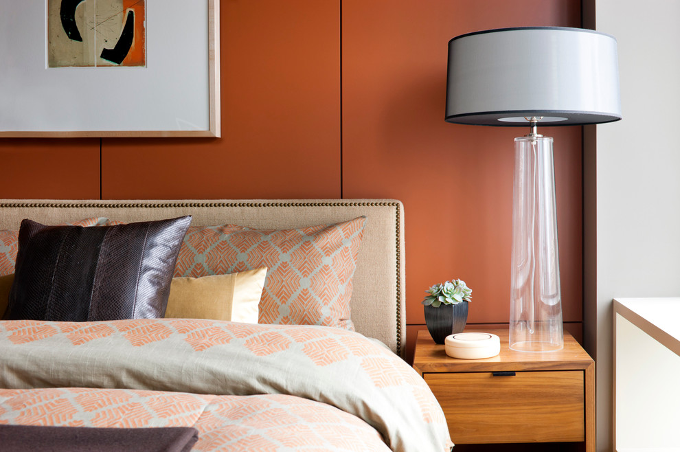 Cette image montre une chambre parentale minimaliste de taille moyenne avec un mur orange et parquet clair.
