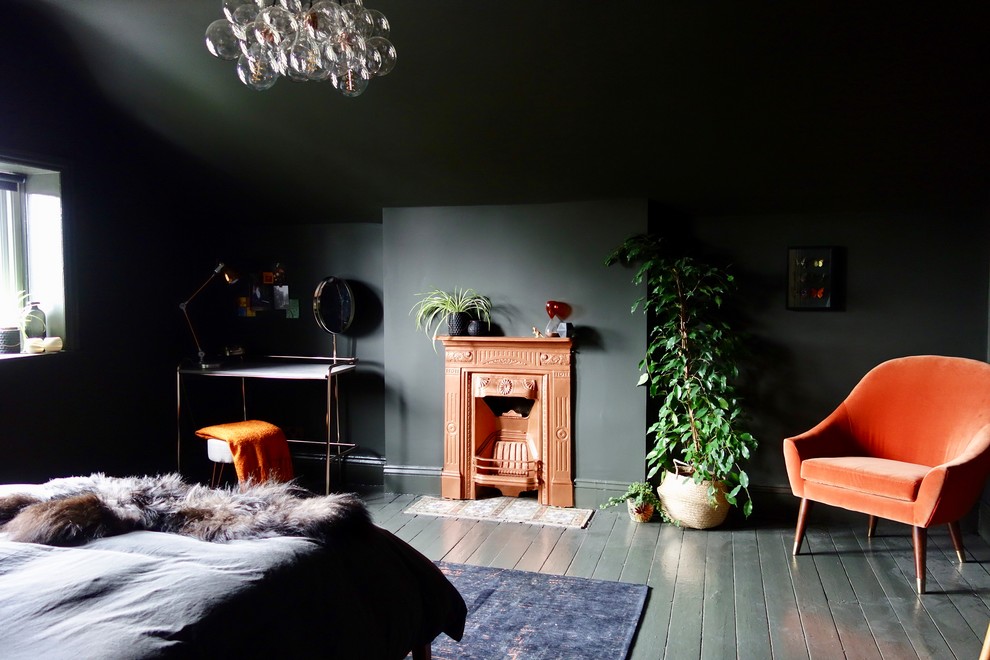 Cette photo montre une grande chambre d'amis éclectique avec un mur gris, parquet peint, une cheminée standard, un manteau de cheminée en métal et un sol gris.