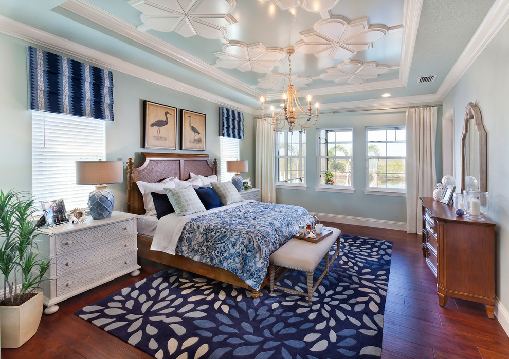 Imagen de dormitorio principal exótico grande con paredes azules, suelo de madera en tonos medios y suelo marrón