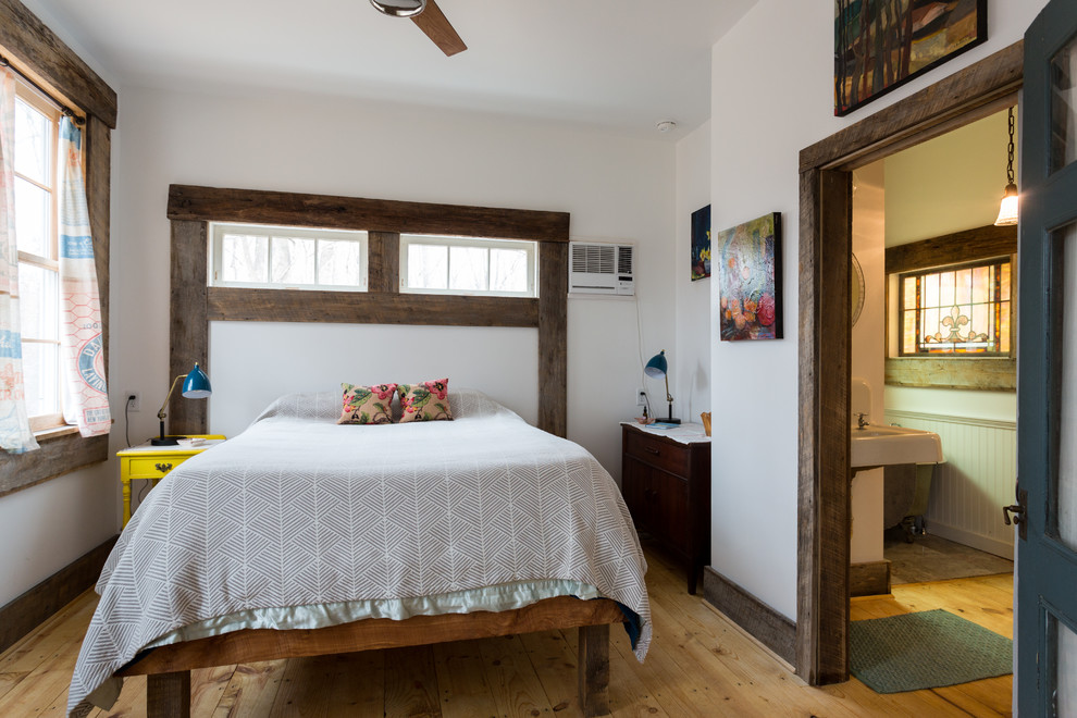 Imagen de dormitorio principal campestre de tamaño medio con paredes blancas y suelo de madera clara