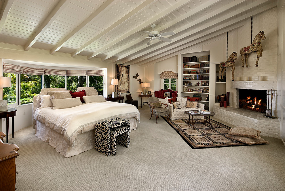 Стильный дизайн: большая хозяйская спальня в средиземноморском стиле с белыми стенами, ковровым покрытием, угловым камином, фасадом камина из кирпича и белым полом - последний тренд
