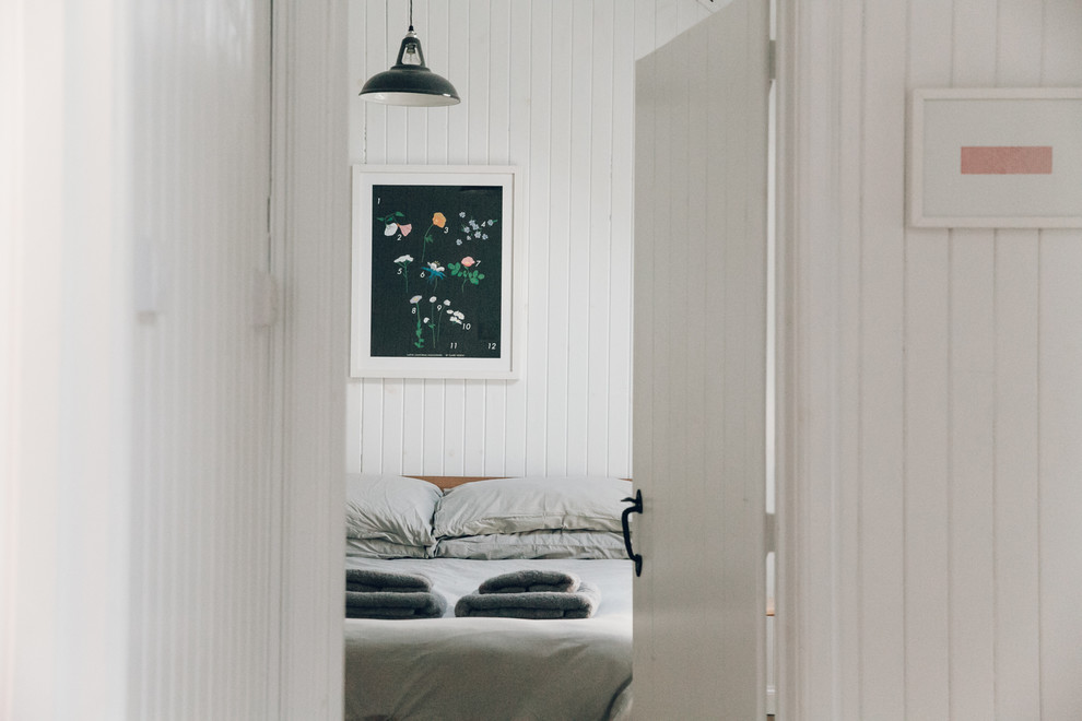 Ejemplo de dormitorio principal escandinavo pequeño con paredes blancas