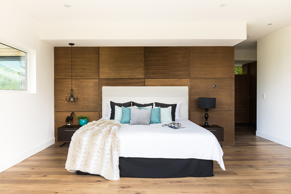 Diseño de dormitorio principal contemporáneo extra grande sin chimenea con paredes blancas, suelo de madera en tonos medios y suelo marrón