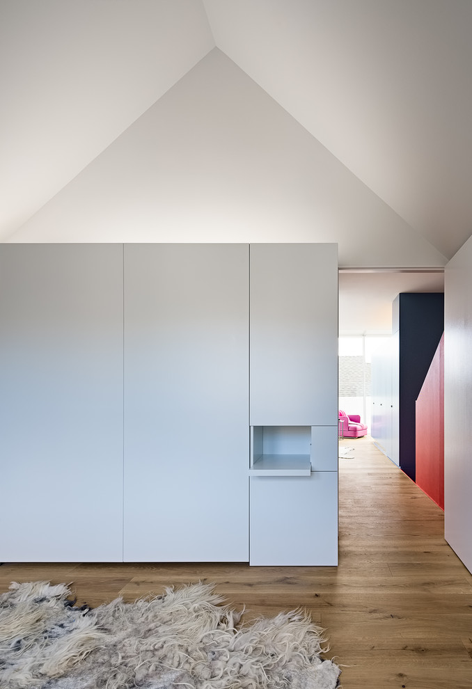 Ispirazione per una piccola camera degli ospiti moderna con pareti bianche, pavimento in legno massello medio e pavimento nero