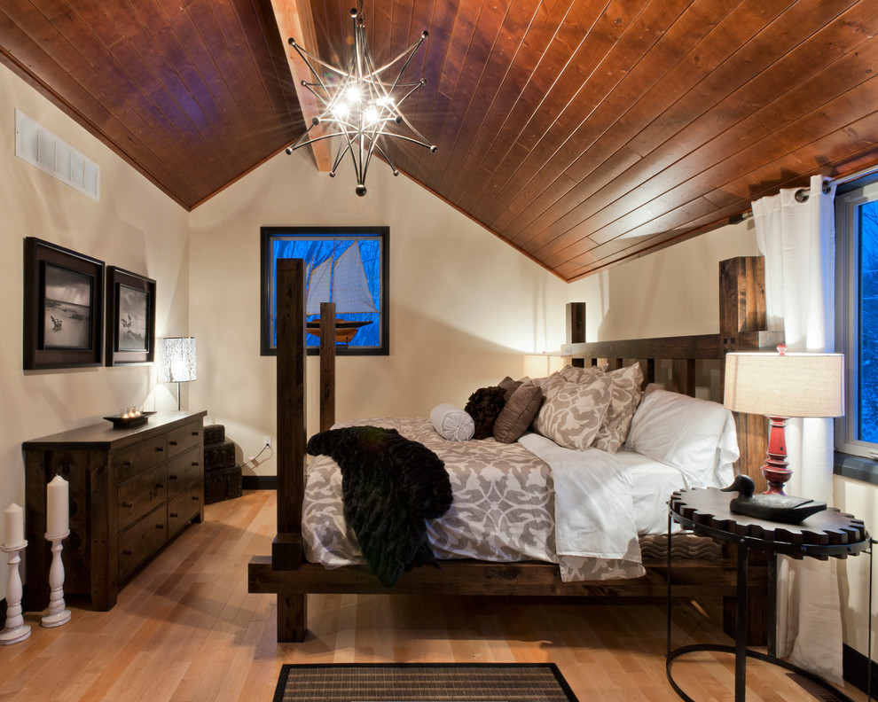 Ejemplo de dormitorio principal rústico de tamaño medio sin chimenea con paredes blancas y suelo de madera clara