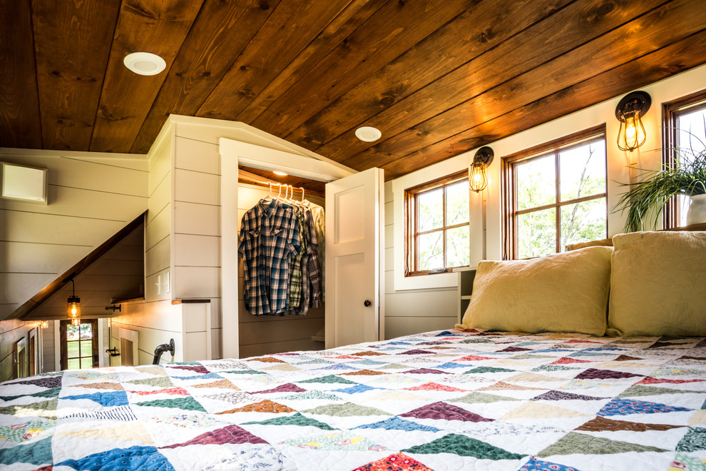 Diseño de dormitorio principal de estilo americano con paredes grises y suelo de madera en tonos medios