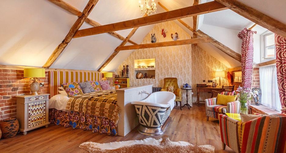 Imagen de dormitorio principal ecléctico grande con suelo de madera en tonos medios, suelo marrón y paredes blancas