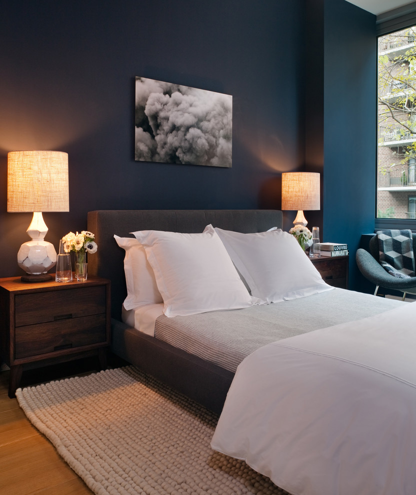 ニューヨークにあるミッドセンチュリースタイルのおしゃれな客用寝室 (青い壁、無垢フローリング、照明) のインテリア