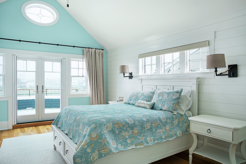 Foto på ett maritimt sovrum, med blå väggar, mellanmörkt trägolv och brunt golv