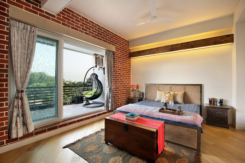 Asiatisches Hauptschlafzimmer mit weißer Wandfarbe und hellem Holzboden in Ahmedabad