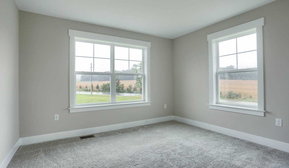 Modelo de habitación de invitados campestre grande con paredes grises, moqueta y suelo beige