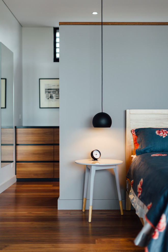 Пример оригинального дизайна: хозяйская спальня в современном стиле с серыми стенами, темным паркетным полом и коричневым полом
