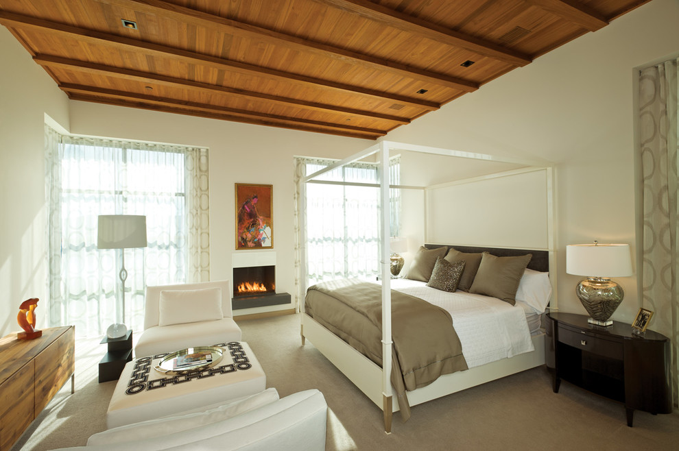 Foto de dormitorio principal contemporáneo de tamaño medio con paredes blancas, moqueta, chimenea lineal y marco de chimenea de piedra