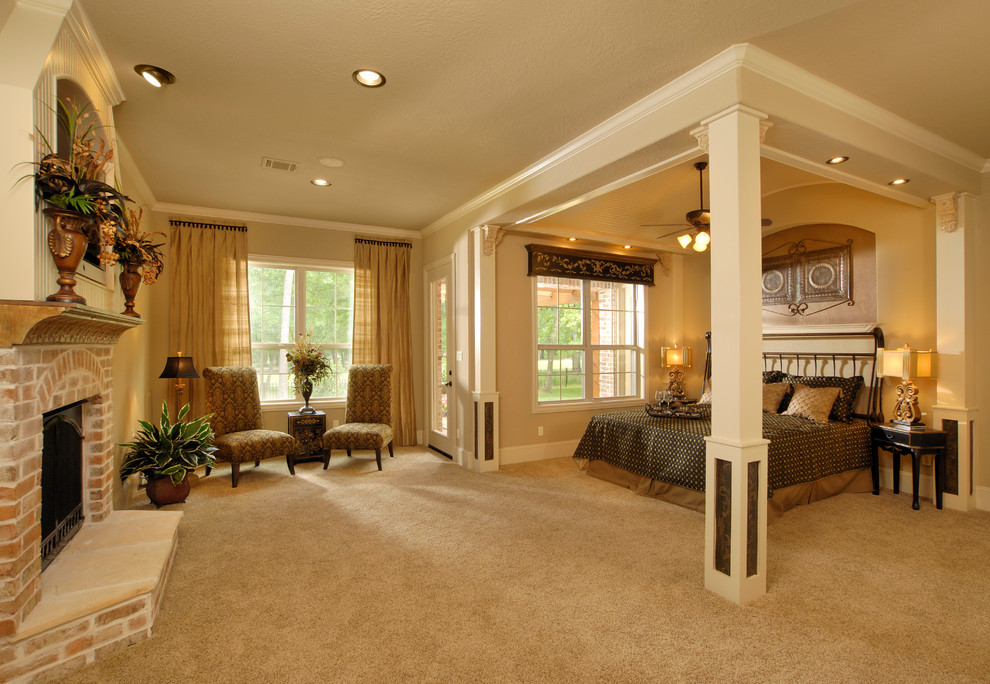 На фото: спальня в классическом стиле с бежевыми стенами, ковровым покрытием, стандартным камином, фасадом камина из кирпича и кроватью в нише