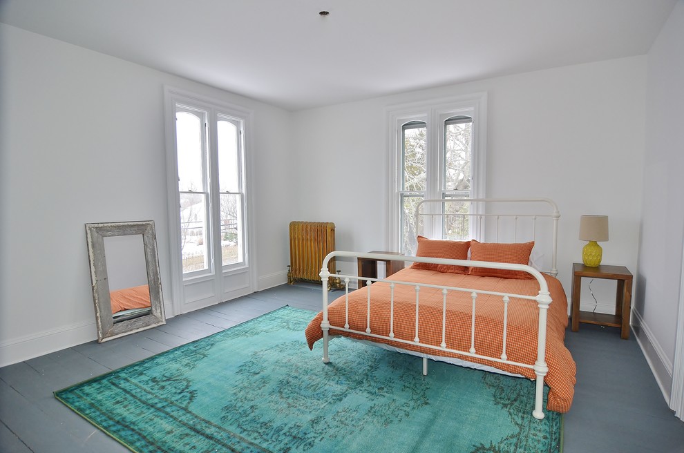 На фото: большая гостевая спальня (комната для гостей) в скандинавском стиле с белыми стенами и деревянным полом с