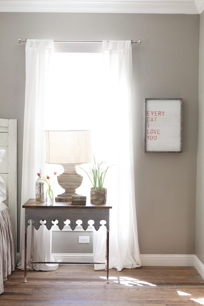 Example of a small cottage master medium tone wood floor bedroom design in Austin with gray walls and no fireplace
