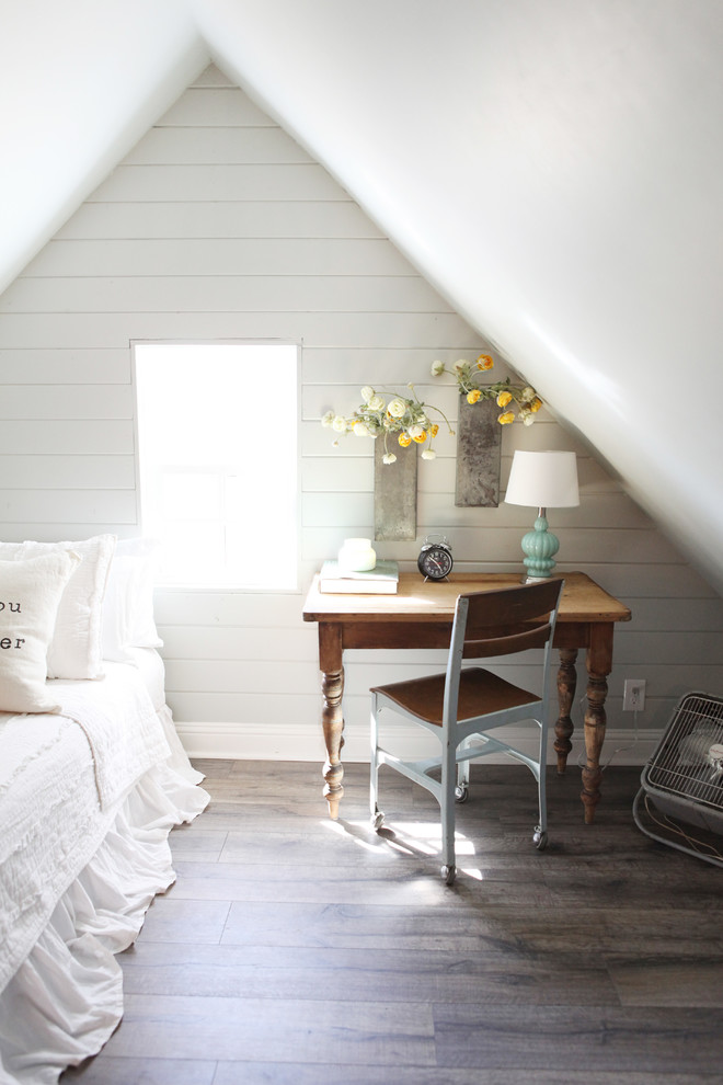 Diseño de habitación de invitados campestre pequeña sin chimenea con paredes grises y suelo de madera en tonos medios