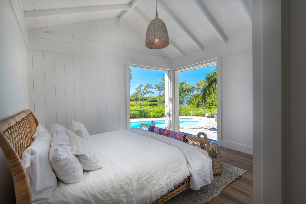 Inspiration for a coastal bedroom in Tampa with white walls, light hardwood flooring and brown floors.