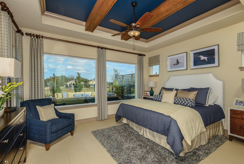 Beach style master bedroom in Tampa with beige walls, no fireplace and beige floors.