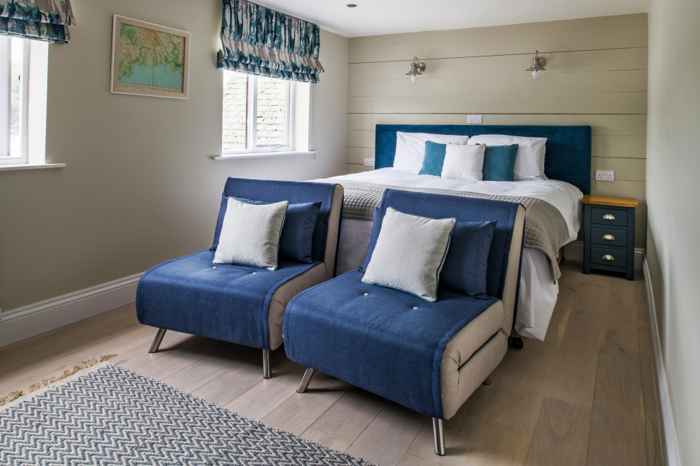 Medium sized nautical guest bedroom in Cornwall with beige walls, light hardwood flooring, beige floors and tongue and groove walls.
