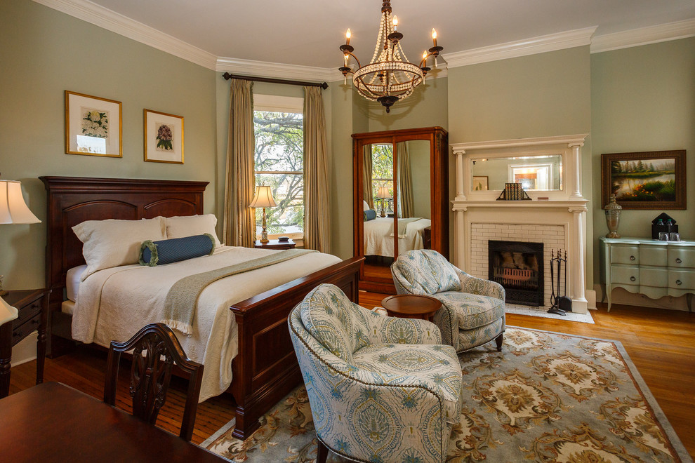 Imagen de dormitorio principal clásico con suelo de madera oscura, todas las chimeneas, paredes verdes y marco de chimenea de baldosas y/o azulejos