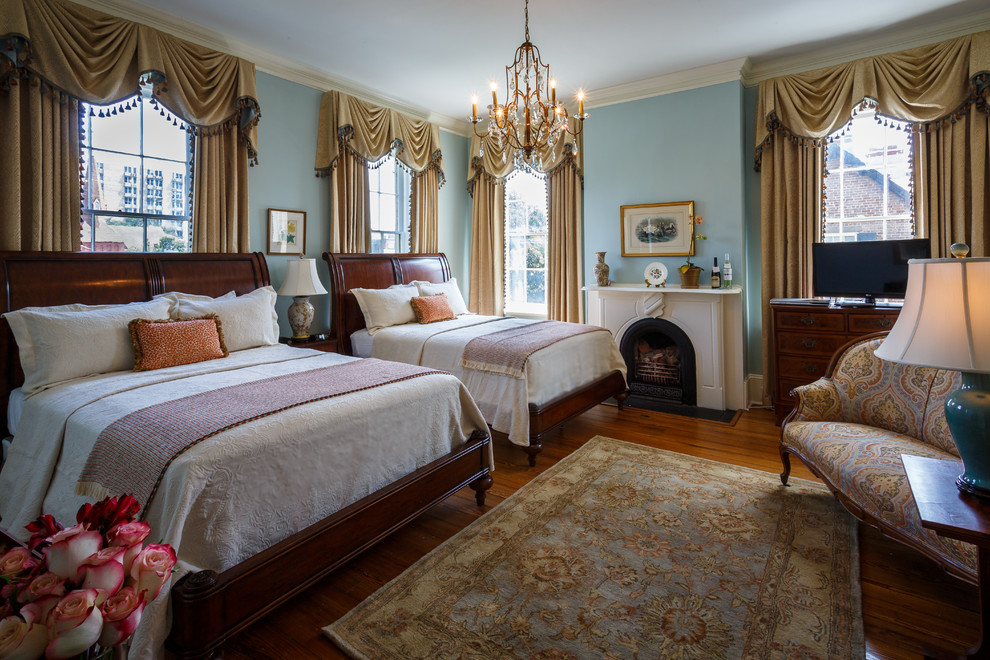 アトランタにあるヴィクトリアン調のおしゃれな主寝室 (青い壁、濃色無垢フローリング、標準型暖炉、木材の暖炉まわり) のインテリア