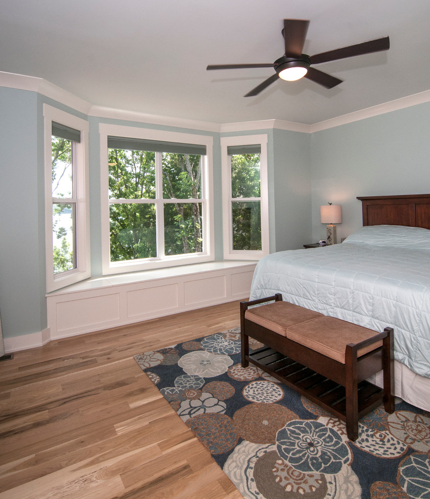 他の地域にある広いトラディショナルスタイルのおしゃれな主寝室 (青い壁、淡色無垢フローリング、暖炉なし) のインテリア
