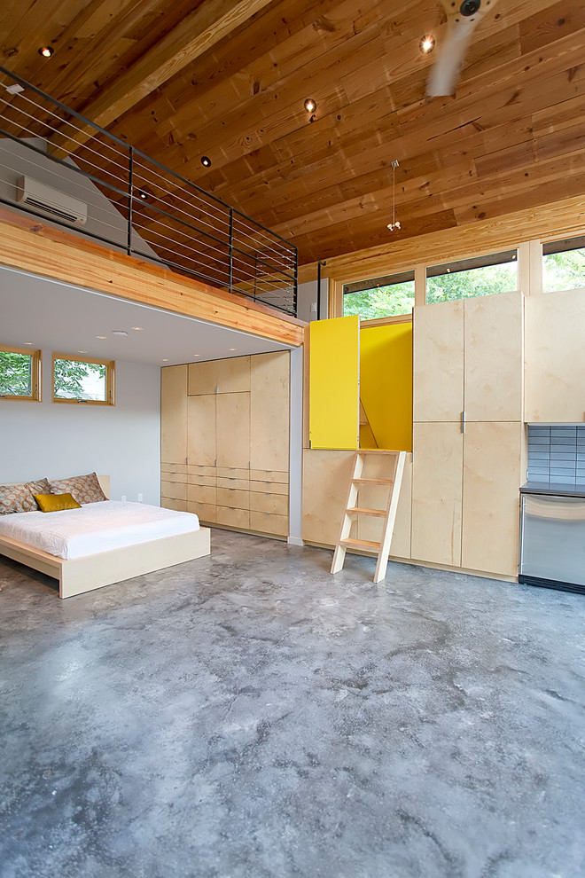 Kleines Modernes Schlafzimmer mit weißer Wandfarbe, Betonboden und grauem Boden in Houston