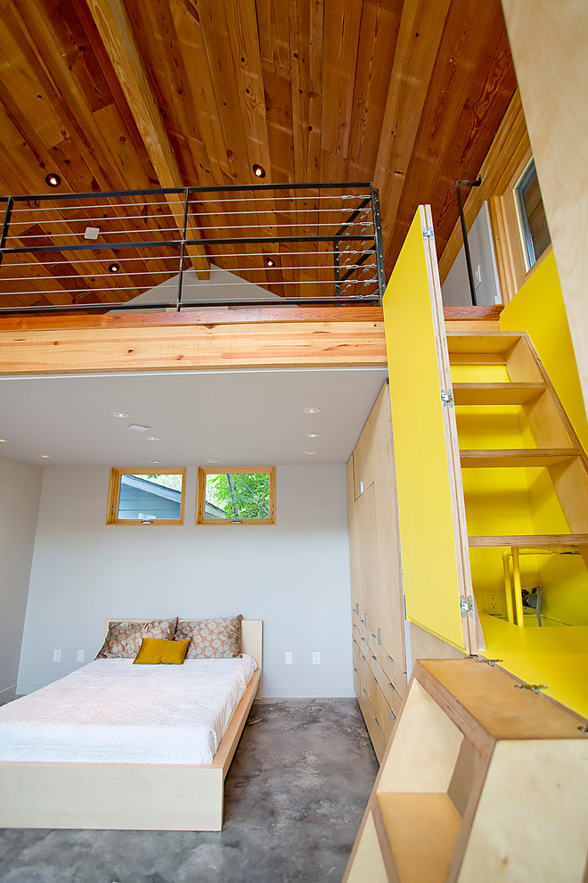 Modernes Schlafzimmer ohne Kamin mit weißer Wandfarbe und Betonboden in Houston