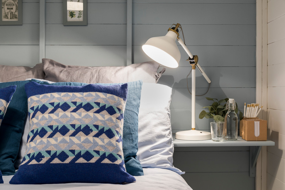 На фото: маленькая гостевая спальня (комната для гостей) в скандинавском стиле с синими стенами, полом из ламината, печью-буржуйкой и серым полом для на участке и в саду