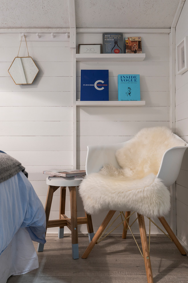 Idee per una piccola camera degli ospiti nordica con pareti blu, pavimento in laminato, stufa a legna e pavimento grigio