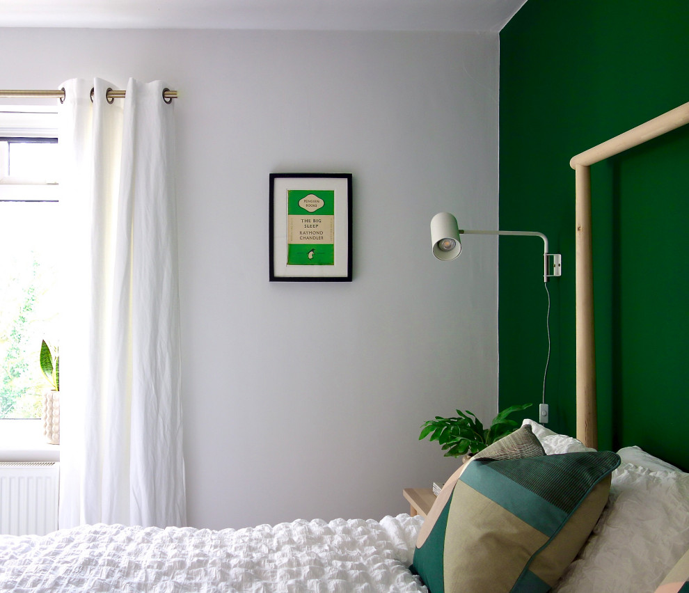 This is an example of a medium sized scandinavian guest bedroom in Other with green walls, carpet and grey floors.