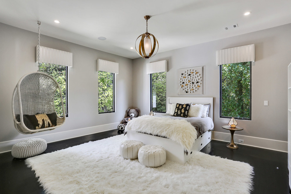 Réalisation d'une chambre design avec un mur gris et parquet foncé.