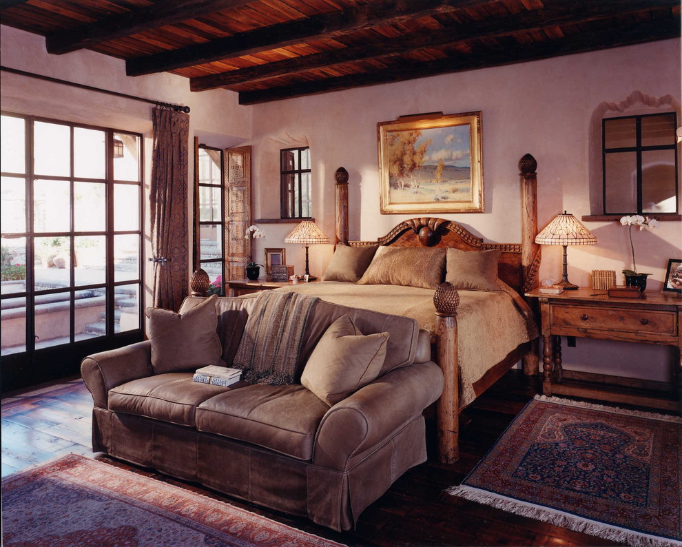 Diseño de dormitorio principal de estilo americano de tamaño medio sin chimenea con paredes beige, suelo de madera oscura y suelo marrón