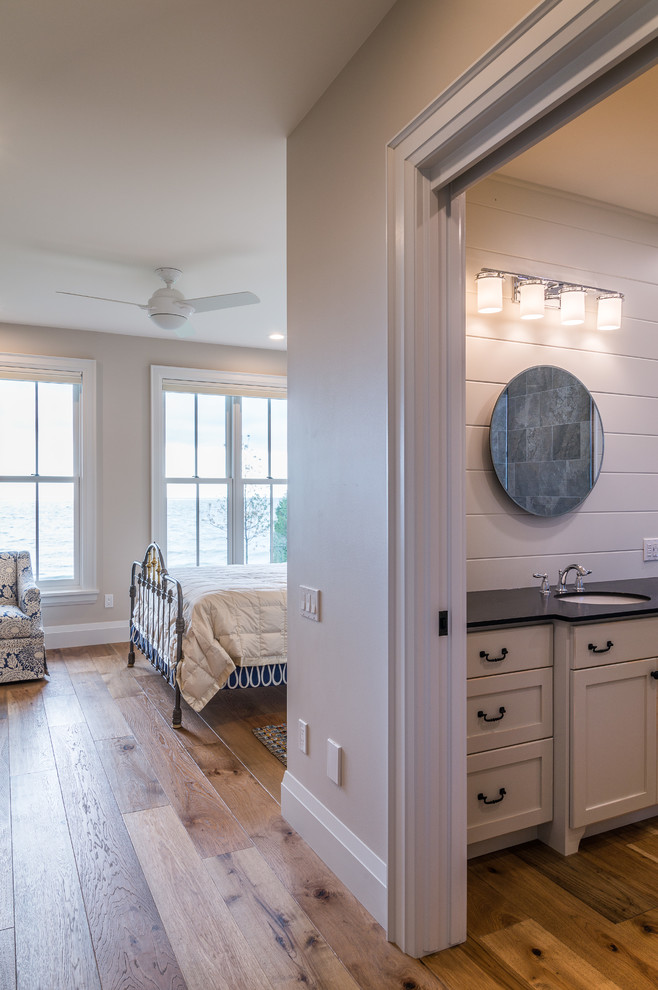 Bedroom - mid-sized coastal master medium tone wood floor bedroom idea in Toronto with beige walls