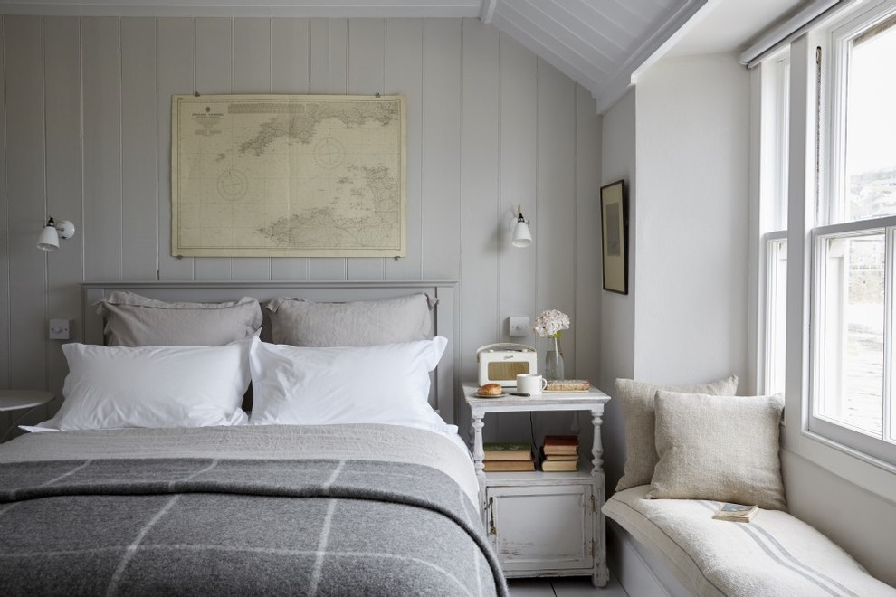 Esempio di una piccola camera matrimoniale stile marinaro con pareti bianche, pavimento in legno verniciato e pavimento bianco