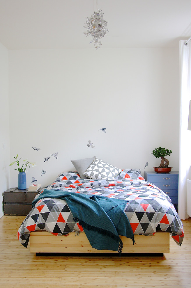 Ispirazione per una camera da letto scandinava con pareti bianche e parquet chiaro