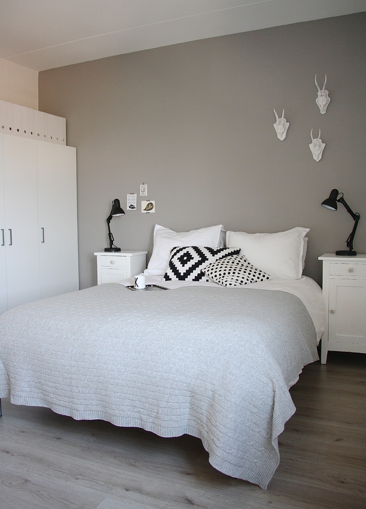 Modelo de dormitorio gris y blanco nórdico con paredes grises y suelo de madera clara
