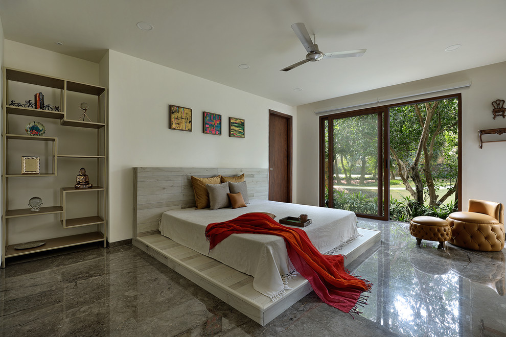 デリーにあるコンテンポラリースタイルのおしゃれな寝室 (白い壁、コンクリートの床、グレーの床) のレイアウト
