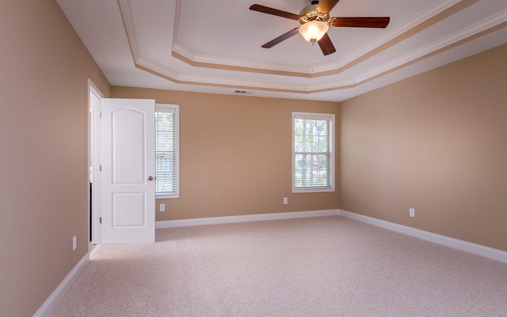 Klassisches Hauptschlafzimmer ohne Kamin mit beiger Wandfarbe und Teppichboden in Sonstige