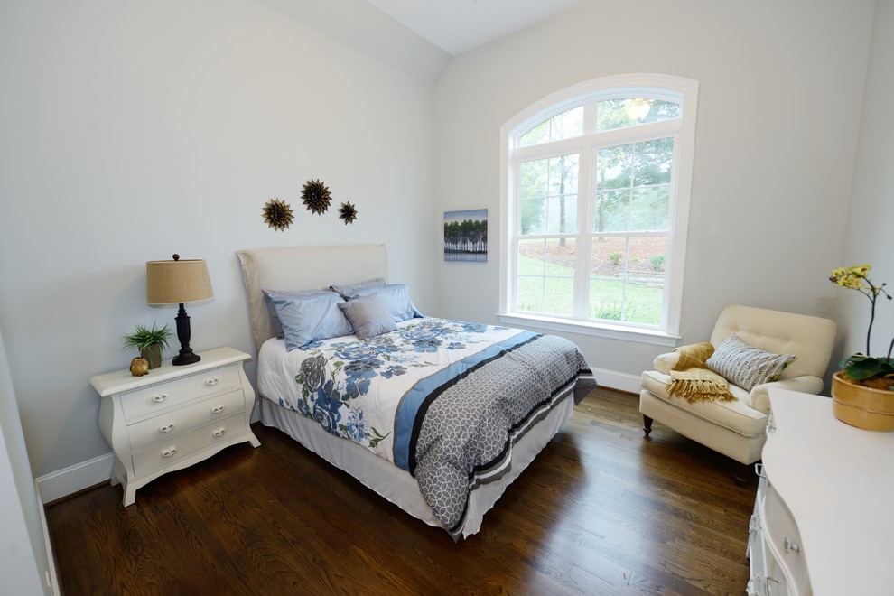 Immagine di una camera degli ospiti chic con pareti grigie e pavimento in legno massello medio