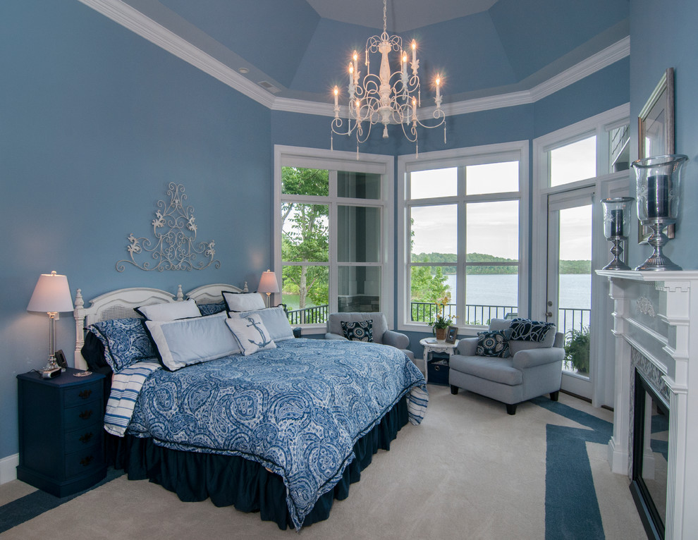 Foto di un'ampia camera matrimoniale eclettica con pareti blu, moquette e camino classico